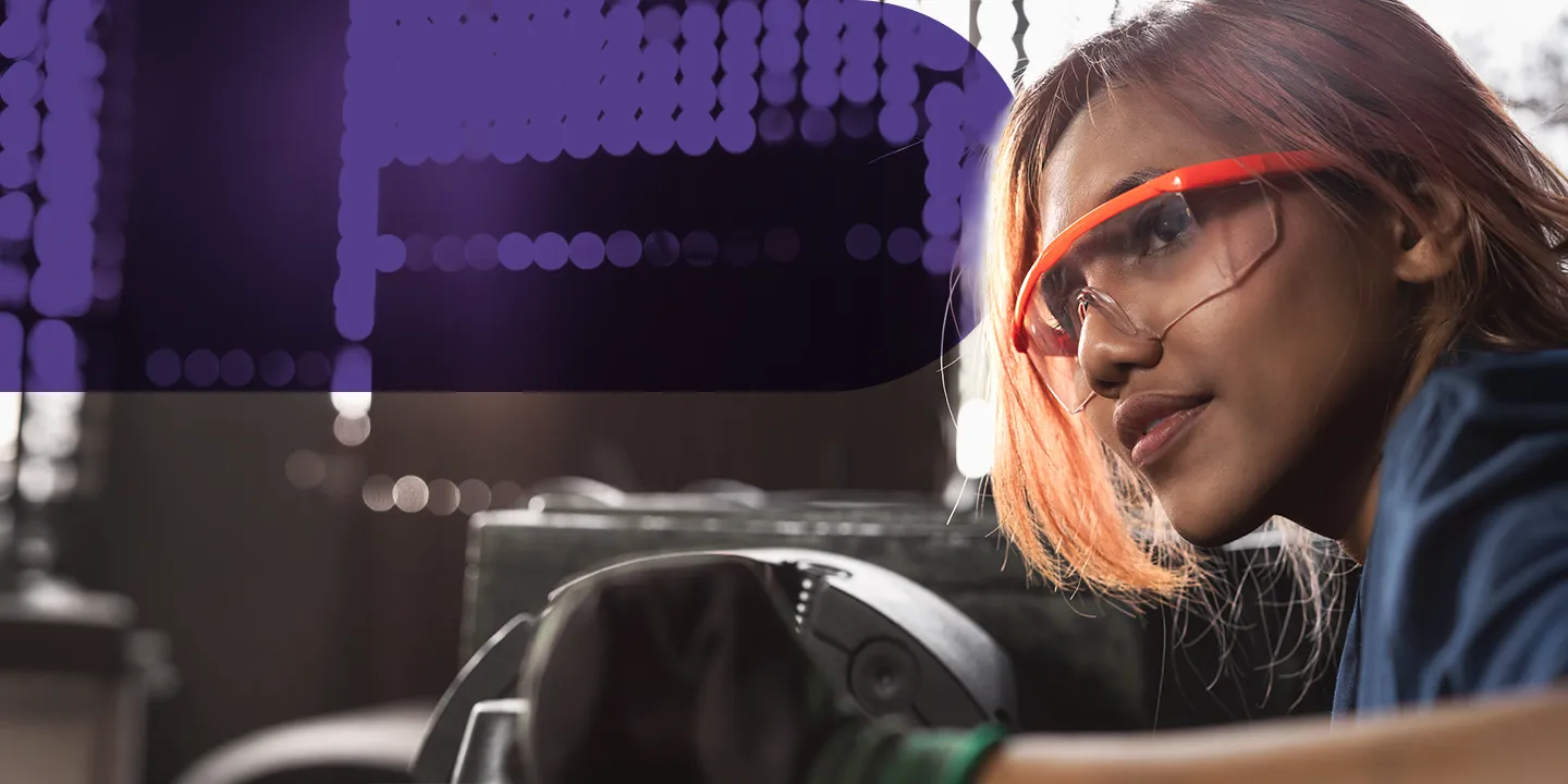 Woman wearing safety glasses working with industrial equipment