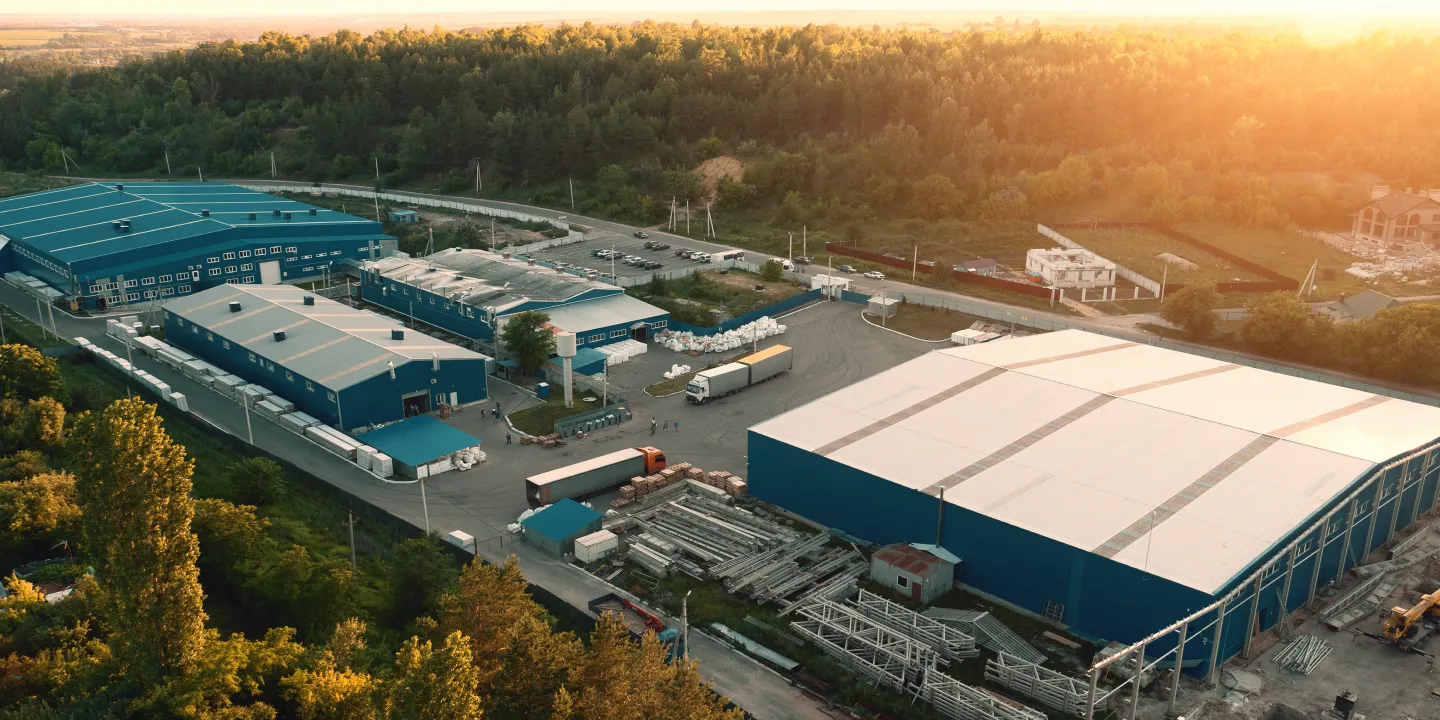 Aerial view of an industrial facility surrounded by trees at sunset