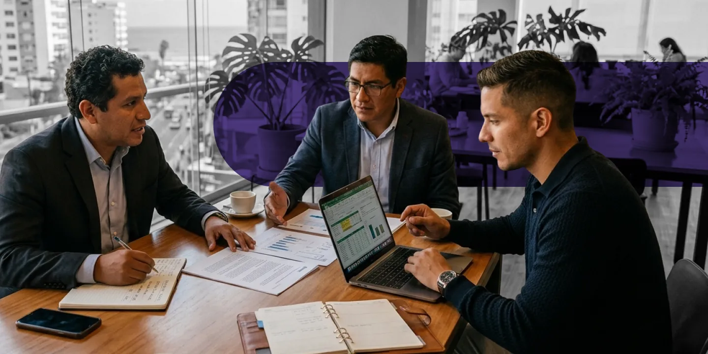 Three business professionals reviewing reports during a meeting