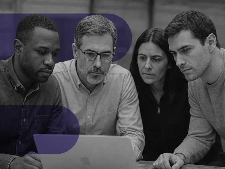 Image of a team gathered around a laptop