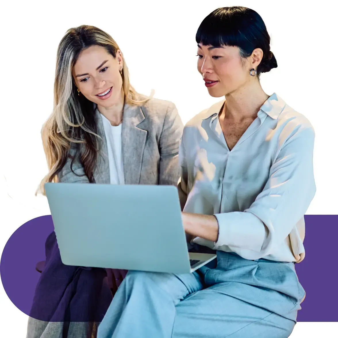 Two diverse women collaborate intently on a laptop computer, sharing a screen.