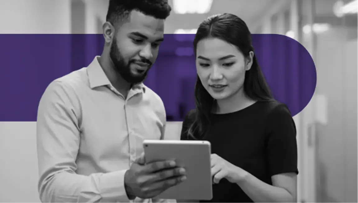 Diverse professionals collaborating on a tablet in a modern office environment.