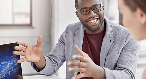 Man in glasses explaining a concept with a digital tablet.